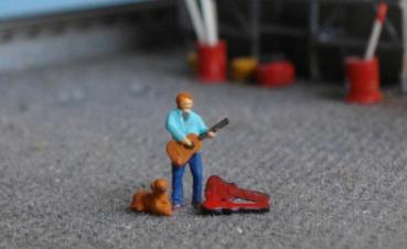 Straßenmusikant mit Hund und Koffer
