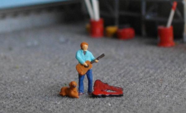 Straßenmusikant mit Hund und Koffer
