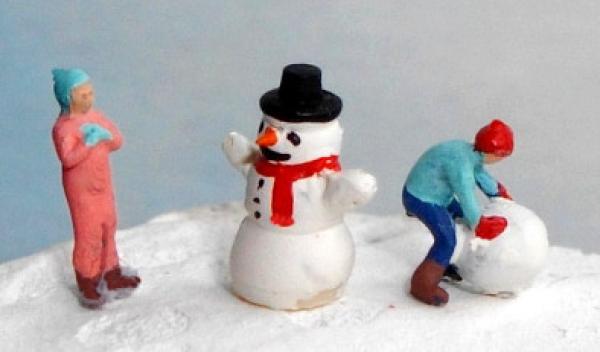 Kinder bauen einen Schneemann